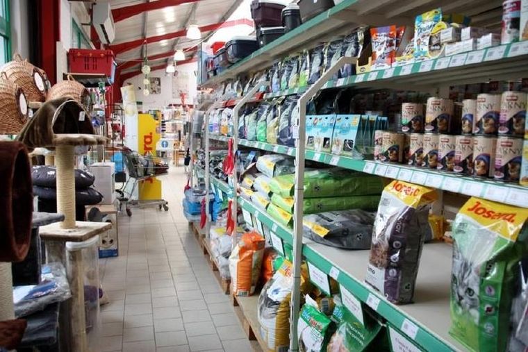 Gang im Fachgeschäft mit Regalen voller Katzenfutter, Kratzbäumen und Haustierzubehör